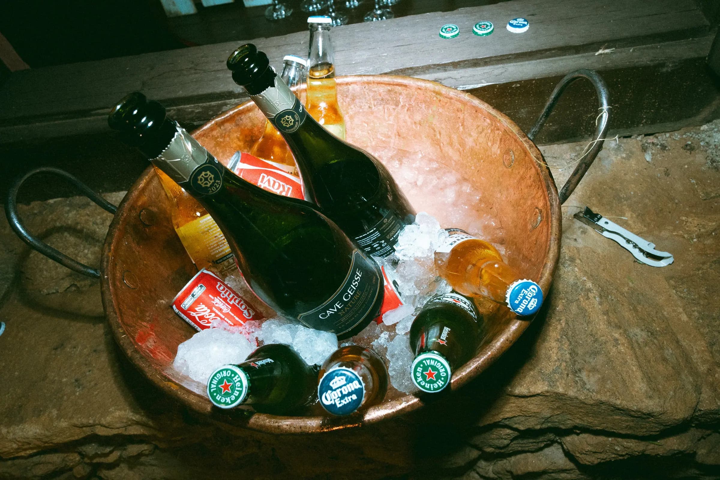 Balde de cobre com espumantes e cervejas gelando no bar