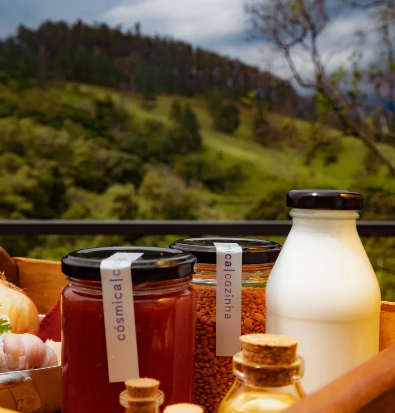 Potes de molho e grãos rotulados cósmica|cozinha ao lado de garrafa de leite, com vista para as colinas da Fazenda ao fundo
