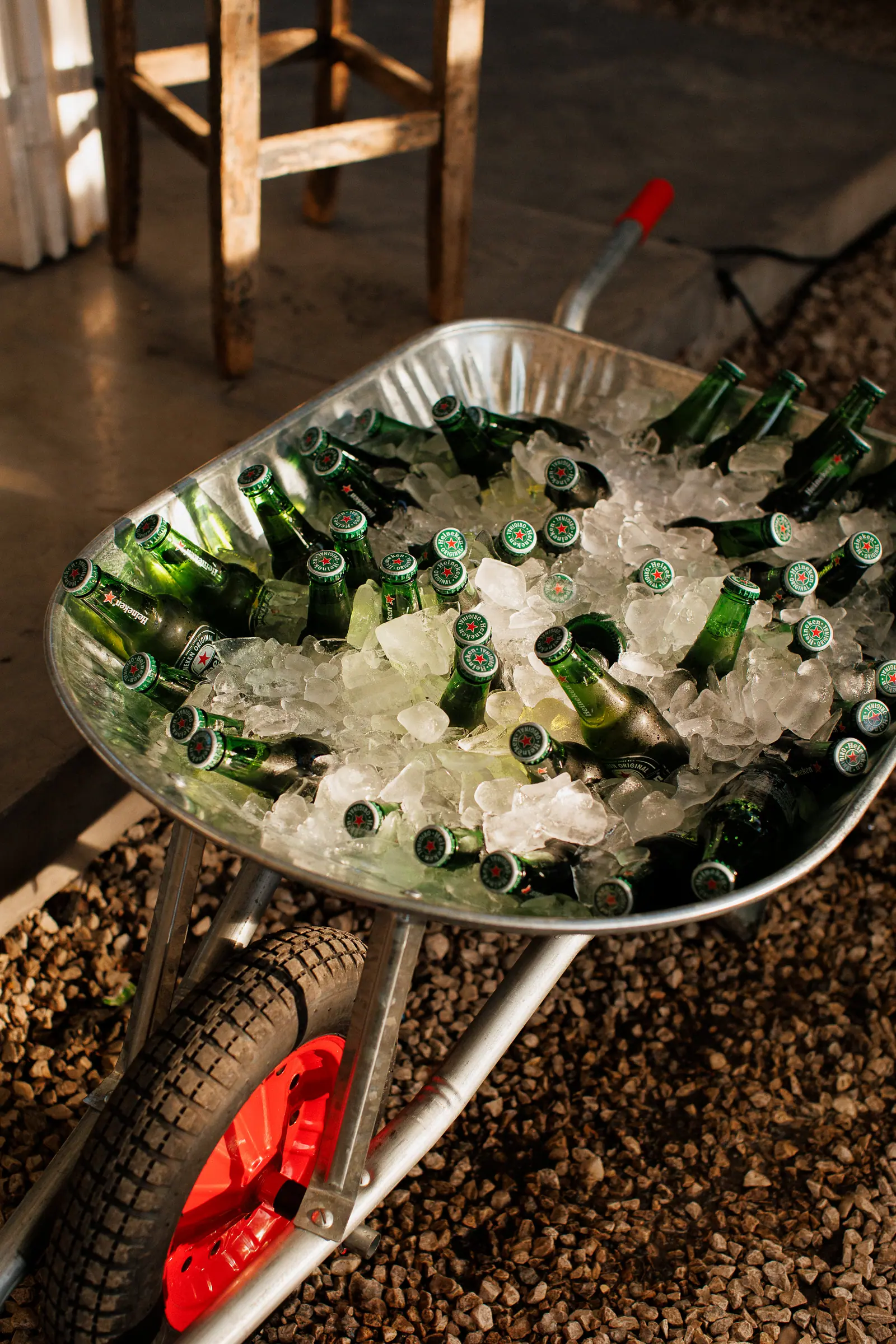 Carrinho de mão cheio de gelo e garrafinhas de Heineken, jeito descontraído de servir cerveja gelada na festa