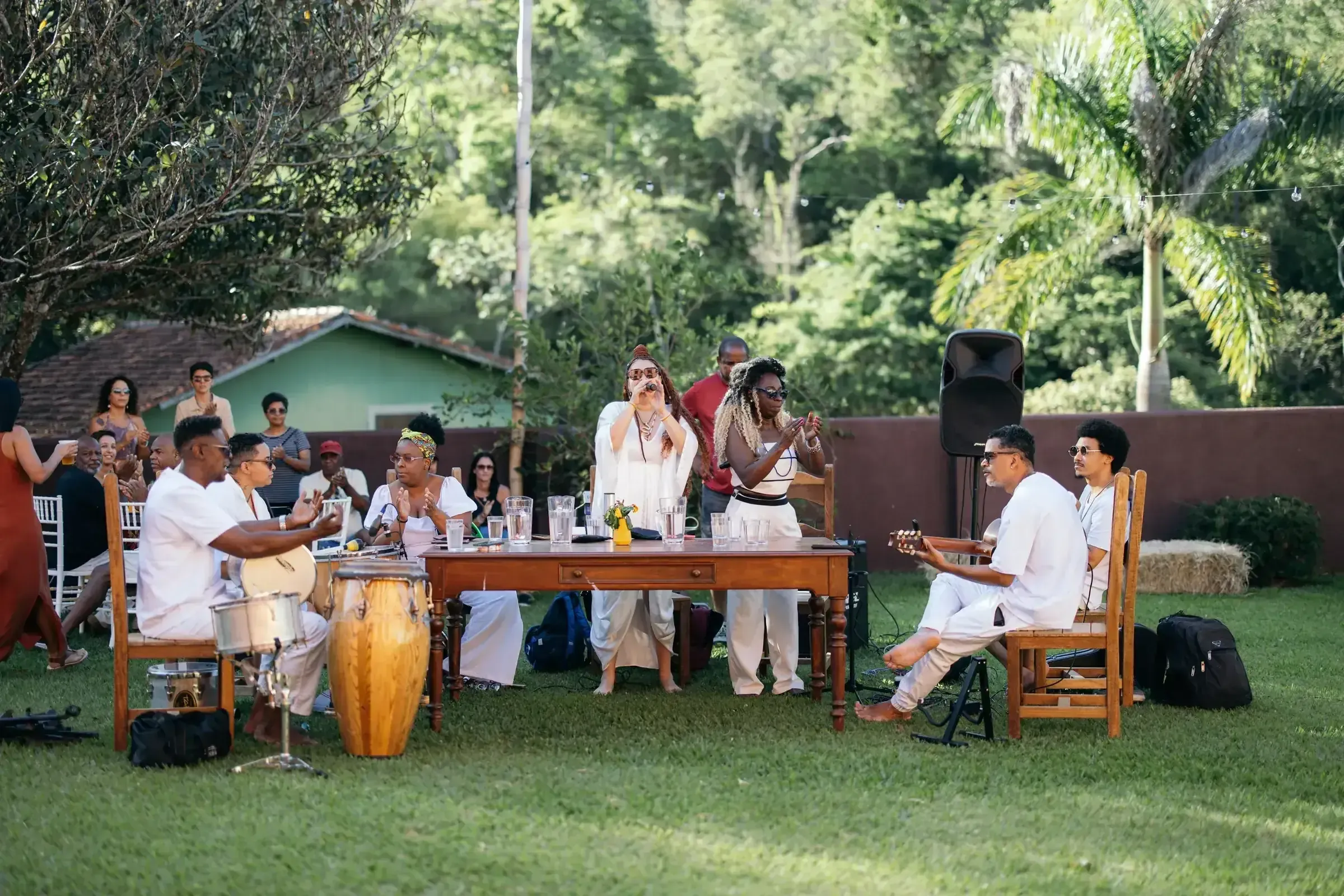 Roda de música com instrumentos de percussão no gramado da Fazenda Cósmica