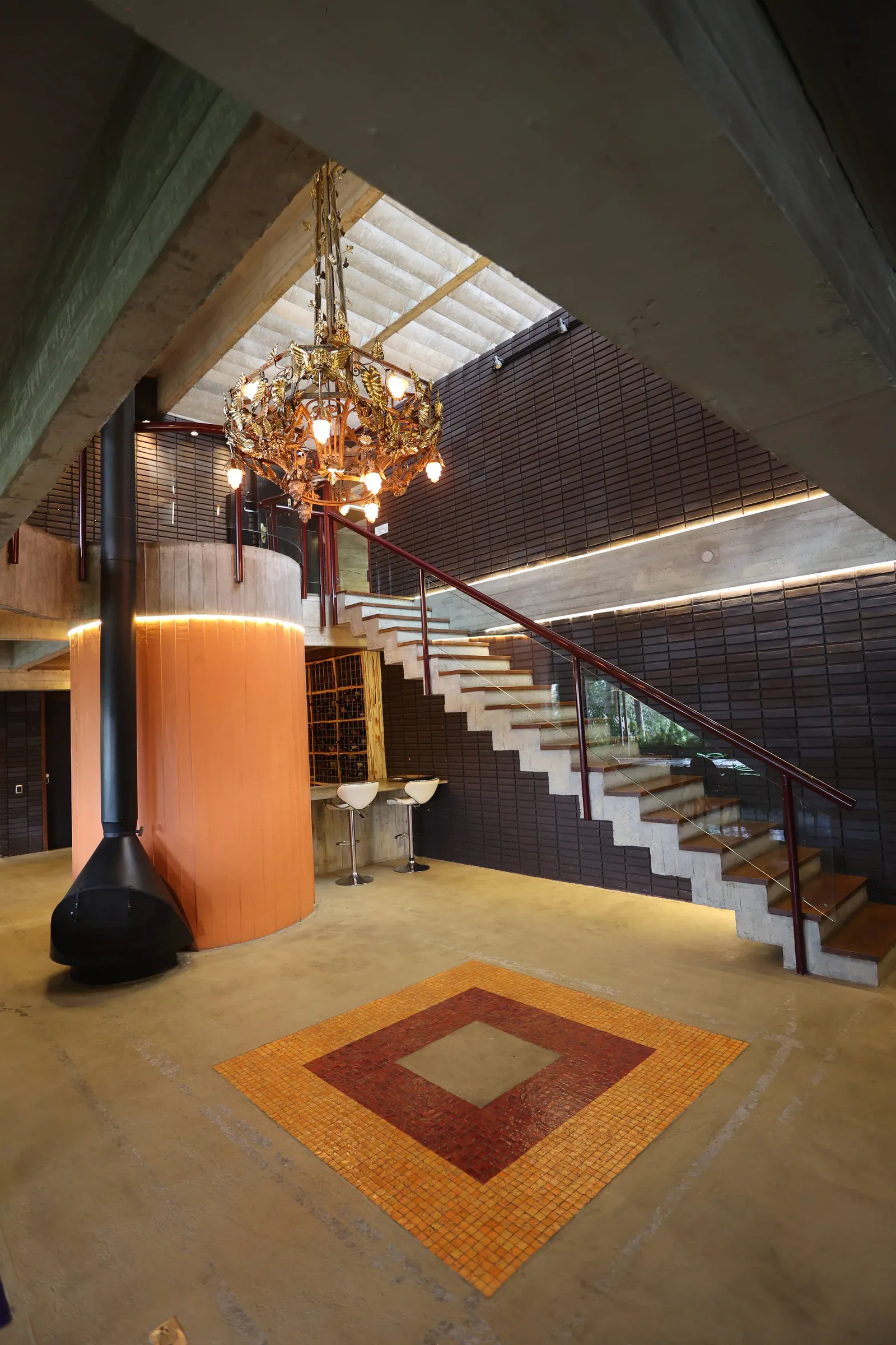 Hall de entrada da Residência Cósmica, com lustre e escada de concreto — arquitetura de Ruy Ohtake em São Paulo