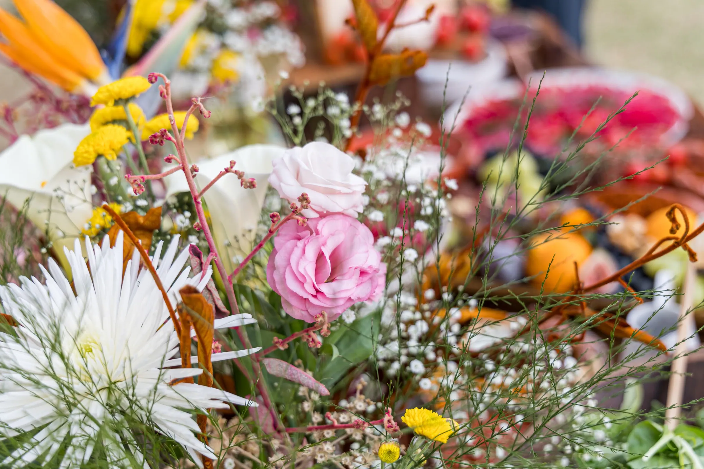 Detalhe de arranjo floral com rosas rosa e brancas, margaridas e flor-de-noiva