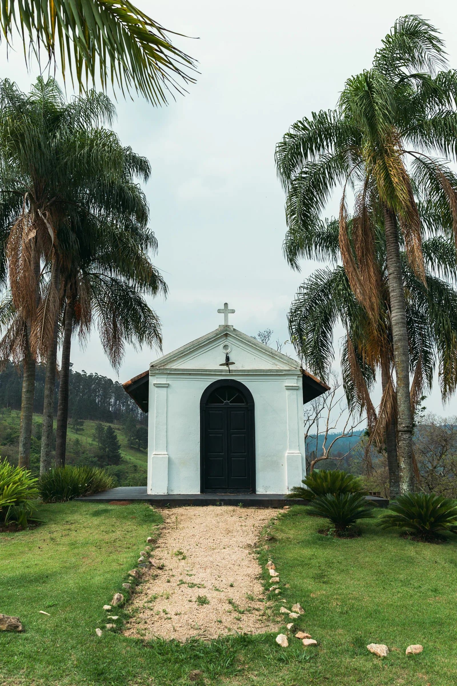 Capela branca entre palmeiras na Fazenda Cósmica para cerimônia de casamento ao ar livre em Amparo