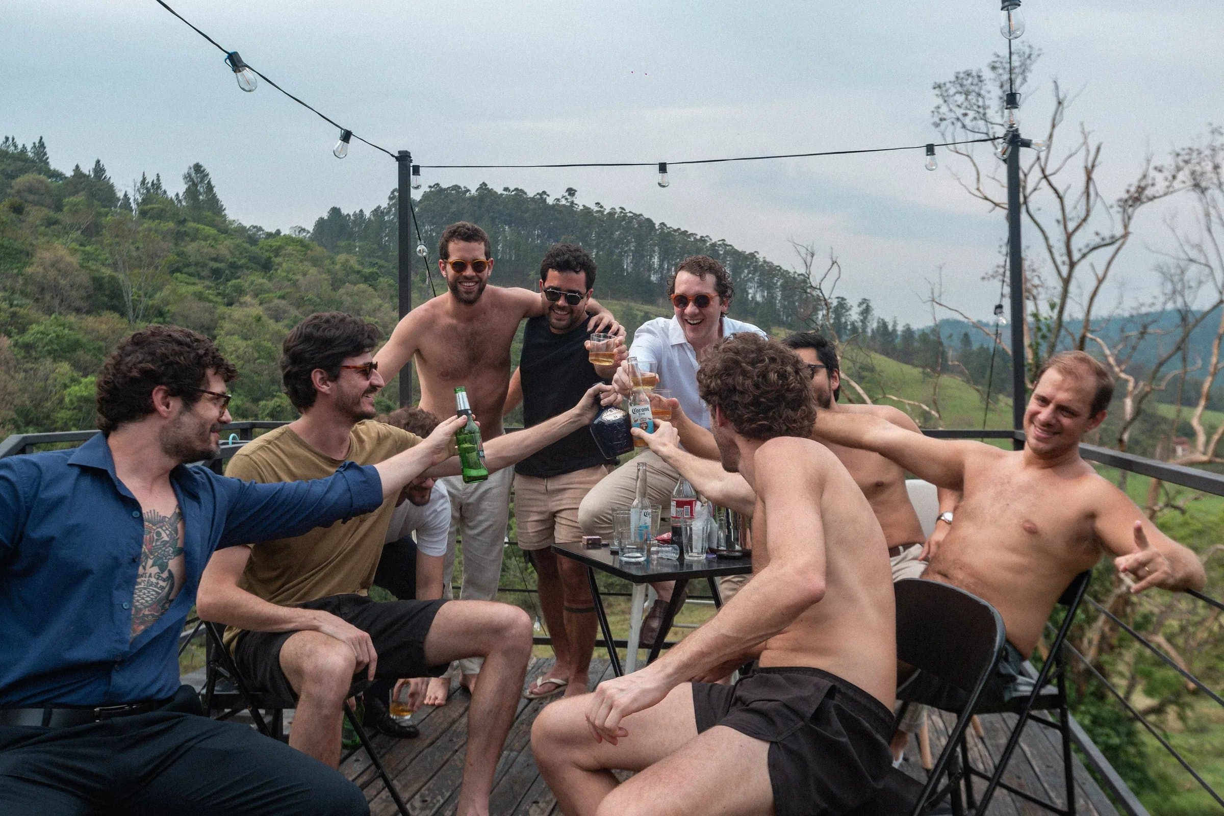 Padrinhos brindando em deque com vista para a mata na Fazenda Cósmica casamento intimista em Amparo