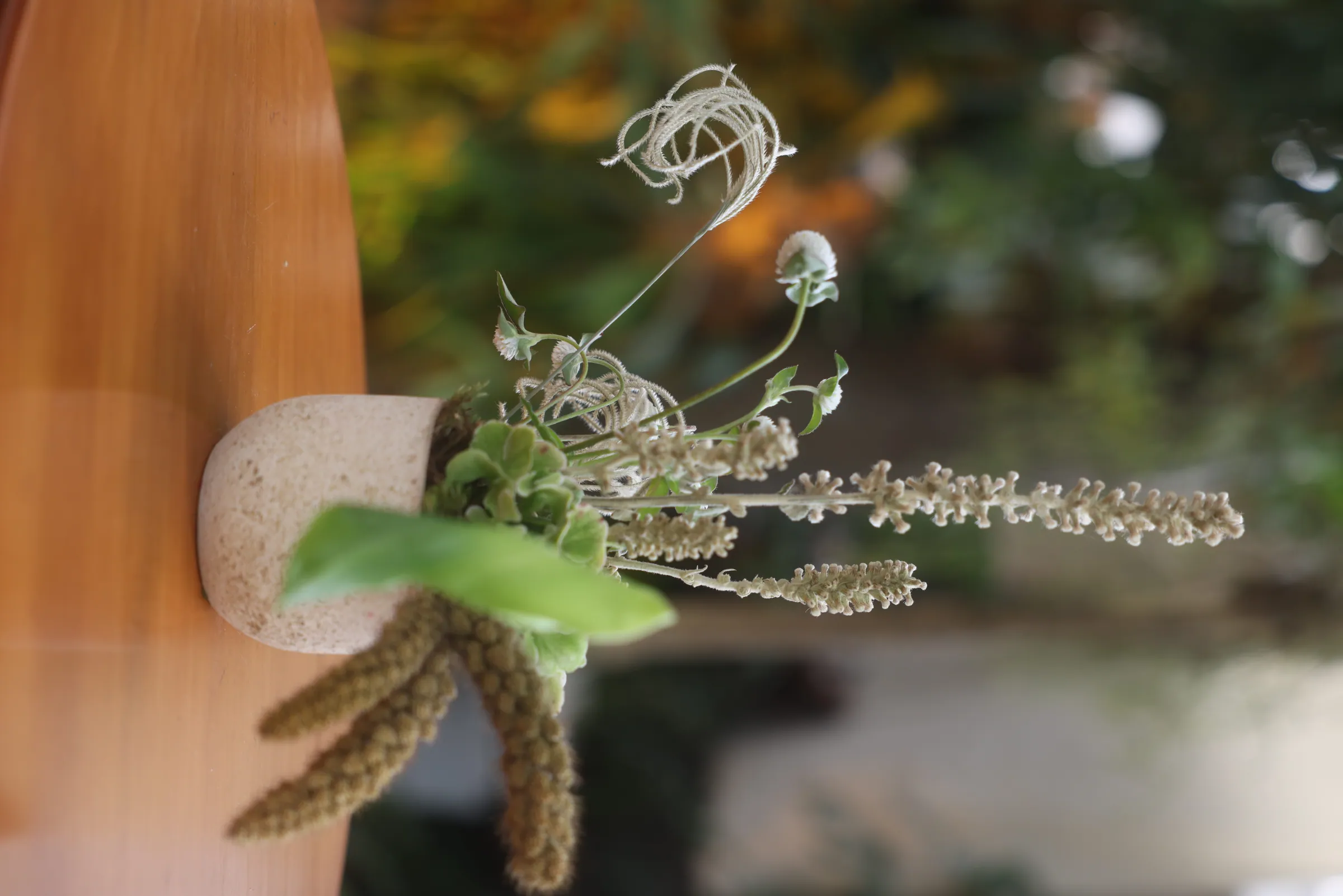 Detalhe de arranjo com folhagens e flores secas em tons naturais, decoração de casamento