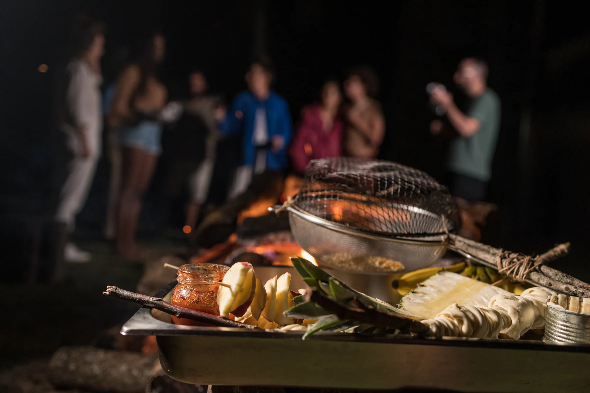 Churrasco na brasa à noite durante festa na Fazenda Cósmica